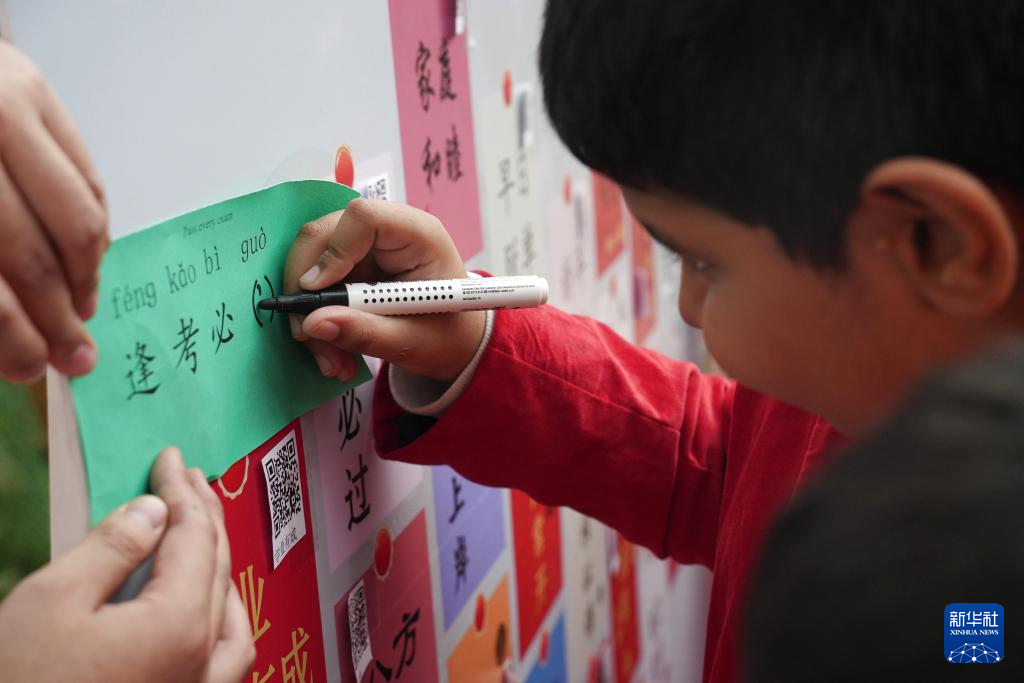1月10日，在孟加拉國(guó)首都達(dá)卡，一名男孩在“歡樂(lè)春節(jié)”廟會(huì)上玩填字游戲。新華社記者 孫楠 攝