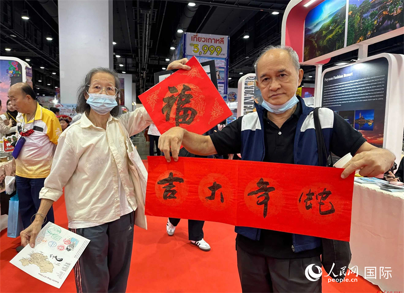 2025蛇年春節(jié)，泰國(guó)市民展示他們領(lǐng)到的華人手寫(xiě)春聯(lián)。人民網(wǎng)記者 簡(jiǎn)承淵攝