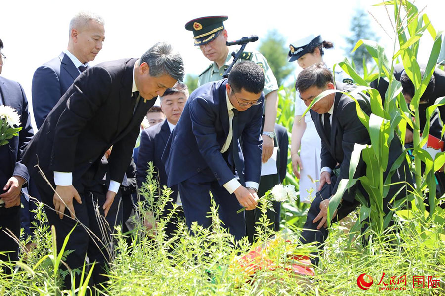 當(dāng)?shù)貢r(shí)間7月25日，祭掃隊(duì)伍面向松骨峰的方向，在莊嚴(yán)肅穆的氣氛中敬獻(xiàn)花束，鞠躬默哀。 人民網(wǎng)記者 劉融攝