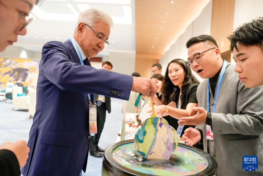 8月31日晚，貴賓們?cè)跉g迎宴會(huì)前體驗(yàn)制作漆扇。