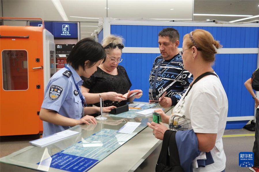 9月15日，上海移民管理警察幫助俄羅斯籍旅客完成入境卡填寫。新華社記者 唐斯琦 攝