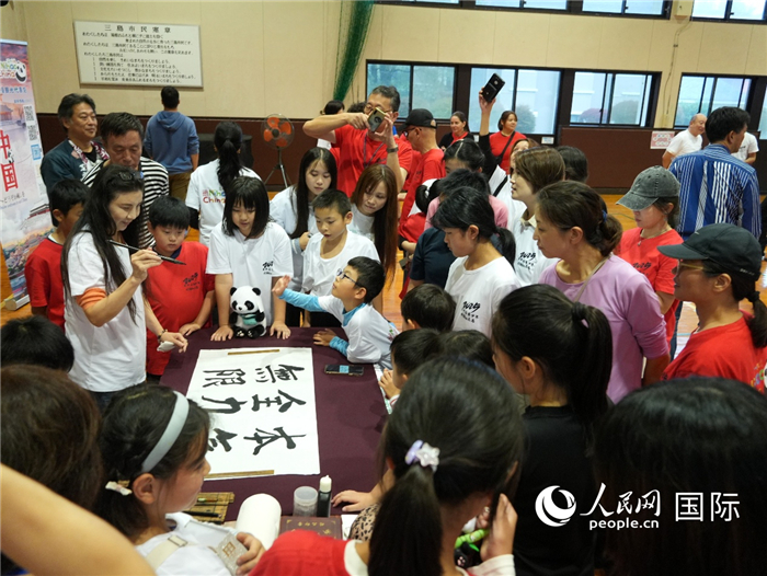 中國書法展示引來眾人圍觀。人民網(wǎng) 許可攝