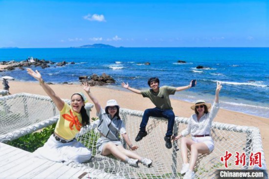 6月8日，華僑大學(xué)“海外新聲代”工作室成員在三亞天涯海角游覽區(qū)合影。 (海南省國(guó)際文化交流中心 供圖)