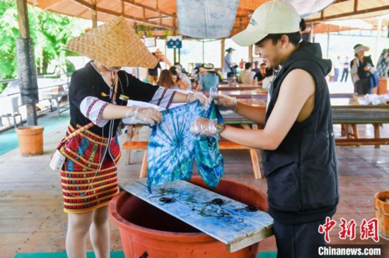 6月9日，印尼博主陳浩杰(右一)在海南檳榔谷黎苗文化旅游區(qū)體驗(yàn)苗族扎染。(海南省國(guó)際文化交流中心 供圖)