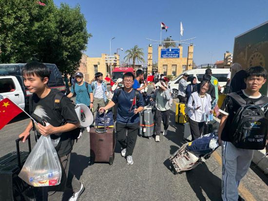6月19日，從以色列撤離的中國公民從埃及南西奈省塔巴口岸進入埃及。新華社發(fā)（艾哈邁德·戈馬 攝）