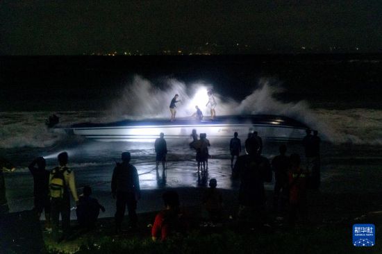 8月5日，在印度尼西亞巴厘島，工作人員將傾覆快艇拉到岸邊。新華社發(fā)（比辛拉西攝）