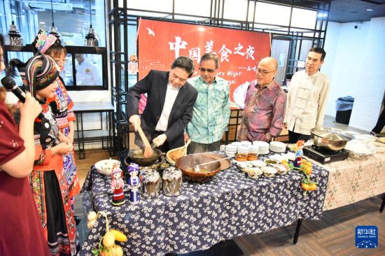 8月23日，在文萊首都斯里巴加灣市的拉克薩馬納商學院，嘉賓在“中國美食之夜——品味廣西”活動上體驗廣西炒茶。新華社記者 李萌 攝